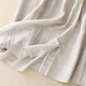 Macro detail of beige cotton linen skirt showing premium fabric texture and hemline