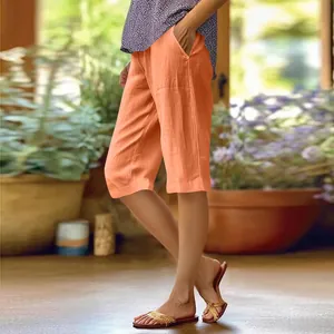 Vue latérale d'une femme portant un short décontracté en coton et lin orange avec poches