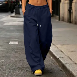 Navy blue wide-leg sweatpants with drawstring and pockets shown in a street setting