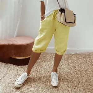 Detail view of yellow cotton linen capri pants with elastic waist and pockets