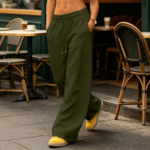 Detail view of olive green wide leg sweatpants with drawstring waist in a street setting