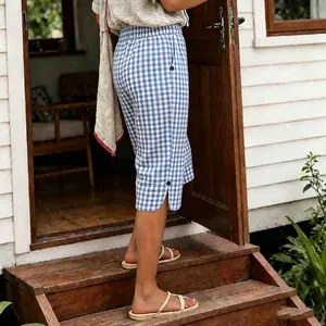 Detail view of vintage blue checkered women's shorts featuring side buttons and slit hem design