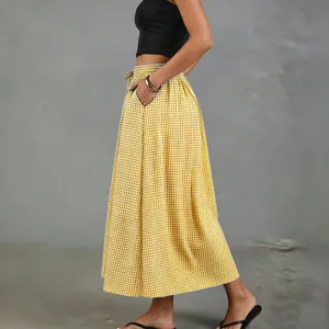 Detail view of yellow and white checkered A-line midi skirt with side pocket