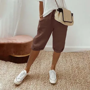 Model wearing brown cotton linen cropped casual pants with drawstring waist and pockets