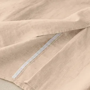 Close-up detail of the breathable cotton linen fabric texture and seam on a beige skirt.