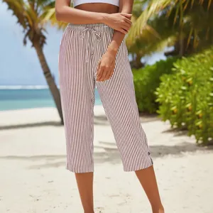 Detail view of brown striped summer cropped pants with drawstring waist on the beach
