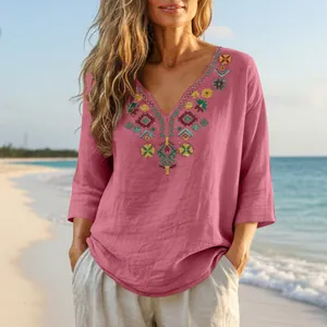 Boho vintage embroidered V-neck linen top with ethnic patterns shown on a beach