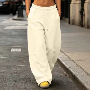 Detail view of cream high-street wide-leg sweatpants with drawstring waist in street context