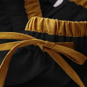 Detailed macro shot of mustard yellow drawstring on black vintage cotton linen skirt
