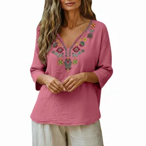 Detailed view of the intricate embroidery on the V-neckline of this pink cotton linen top.