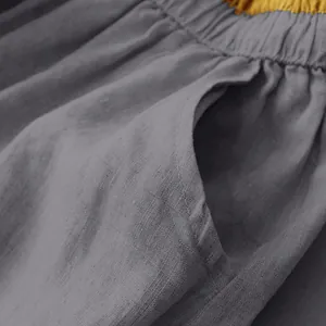 Close-up detail of gray cotton linen skirt fabric showing side pocket and texture