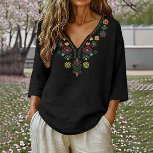 Detailed view of bohemian style V-neck top with colorful floral embroidery