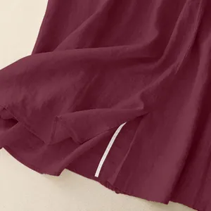 Close-up of wine red cotton linen skirt showing fabric texture and side slit