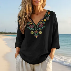 Detail view of colorful bohemian embroidery on black cotton linen V-neck tunic blouse