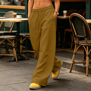 Detail view of mustard yellow wide-leg sweatpants featuring a drawstring elastic waist.