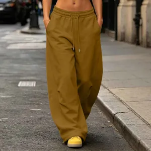 Detailed view of baggy wide-leg sweatpants with drawstring waist in urban street setting