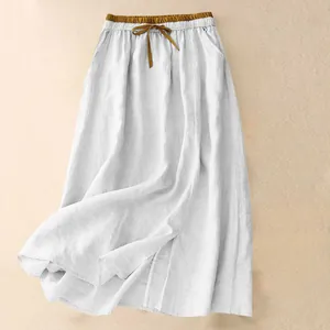 Detail of white cotton linen long skirt featuring contrast elastic waist and drawstring.