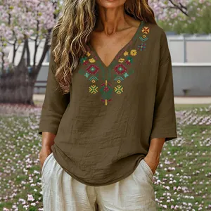 Detailed view of a vintage brown V-neck cotton linen blouse with colorful embroidery.
