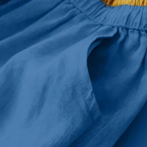 Close-up of side pocket and gathered waist detail on blue linen-textured skirt