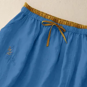 Detailansicht lässiger blauer Hosenrock mit hohem Bund und senfgelbem Kordelzugband
