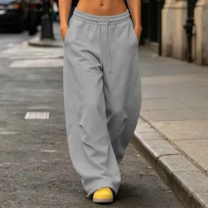 High-waist gray wide-leg floor-length sweatpants with elastic drawstring waist on street