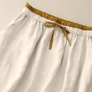 Detail of high waisted cotton linen skirt with mustard yellow drawstring waistband