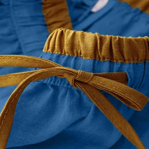 Close-up of a high waist blue skirt with a yellow elastic waistband and drawstring detail