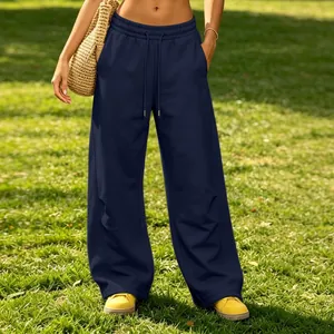 Stylish navy blue wide-leg drawstring sweatpants shown in a sunny outdoor park.