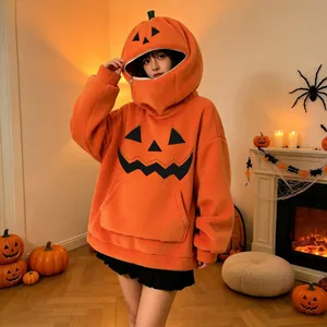 Modella che indossa una felpa con cappuccio a zucca oversize in ambiente Halloween