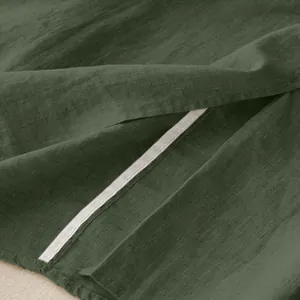 Detailed macro shot of the linen fabric and seam on a dark green midi skirt