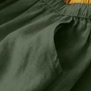 Close-up detail of dark green cotton linen midi skirt showing pocket and fine fabric texture