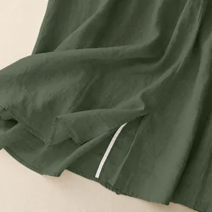 Macro detail showing the hem and slit on a forest green cotton linen retro long skirt
