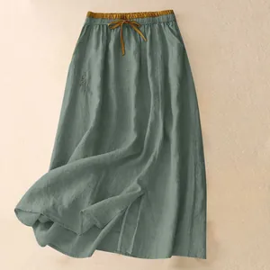 Detail des salbeigrünen, losen Maxirocks mit hoher Taille, Kordelzug und Stickerei.