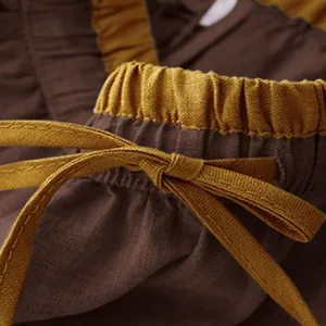 Close-up detail of the elastic waist and mustard drawstring on a brown linen skirt.
