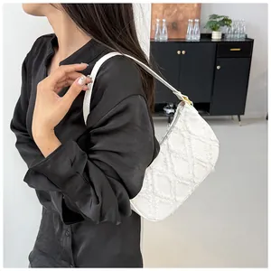 Close-up detail of a white frayed denim underarm shoulder bag with diamond pattern
