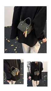 Lifestyle-Detailaufnahmen einer dunkelgrünen Vintage-Boston-Handtasche mit Perlenanhänger.