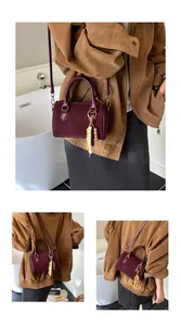 Detailansichten einer weinroten Boston-Handtasche im Vintage-Stil mit Perlenanhänger