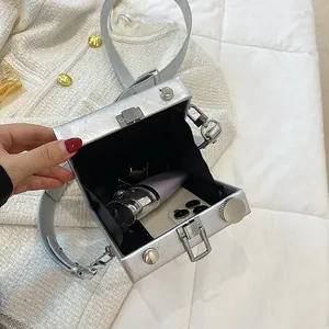Sac caméra rétro en métal argenté avec fini texturé, présenté ouvert sur surface blanche