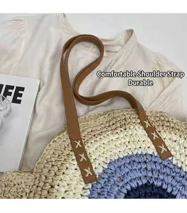 Close-up of durable brown leather straps on a circular woven straw beach bag