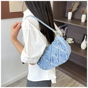 Back view of model wearing a blue frayed denim hobo bag with diamond pattern