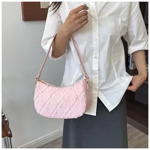 Close-up of pink quilted denim shoulder bag with chic frayed edge detailing.
