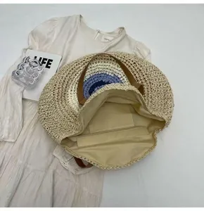 Macro view showing the interior zip pocket and lining of a round straw beach bag.