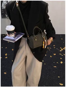 Vintage dunkelgrüne Boston Tasche mit Perlenanhänger für stilvolle Streetwear-Outfits.