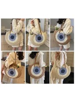 Stylish handmade circular woven straw shoulder bag with eye design shown on model