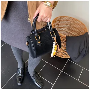 Detailaufnahme einer schwarzen Vintage-Boston-Handtasche mit bunter Perlenquaste