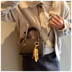 Elegante braune Boston Tasche für Damen mit Perlenanhänger und praktischem Umhängeriemen