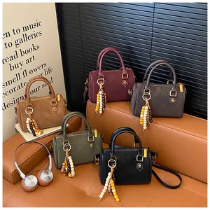 Premium Damenhandtaschen im Vintage Boston Stil in fünf Farben auf einem Ledersofa
