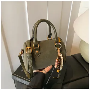 Detailansicht einer olivgrünen Vintage Boston Tasche mit stilvollem Holzperlen-Quastenanhänger