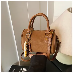 Klassische braune Boston-Handtasche mit stilvollem Holzperlen-Anhänger und Goldakzenten