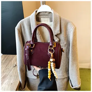 Elegante weinrote Vintage-Boston-Handtasche mit einem einzigartigen bunten Perlenanhänger